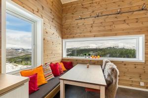 een kamer met een bank met een tafel en een raam bij Tiny mountain cabin with a panoramic view in Giljane