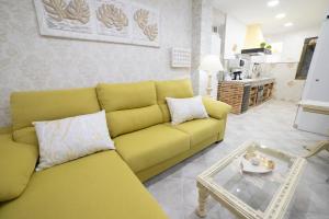 APARTAMENTO LA VEGUILLA JUNIOR في ألهاما دي أراغون: غرفة معيشة مع أريكة صفراء وطاولة