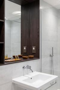La salle de bains est pourvue d'un lavabo et d'un miroir. dans l'établissement COVE Cannon Street, à Londres