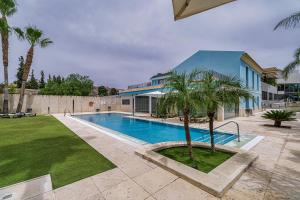 - une piscine avec un palmier à côté d'un bâtiment dans l'établissement Spa Jardines de Lorca, à Lorca