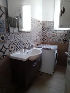 ein Badezimmer mit einem Waschbecken und einem kleinen Kühlschrank in der Unterkunft casa pita mini in Torre Colimena
