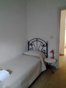Schlafzimmer mit einem Bett und einer roten Lampe auf dem Tisch in der Unterkunft casa pita mini in Torre Colimena