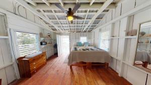 a bedroom with a bed and a ceiling fan at Ranguana Caye Cabanas in Placencia