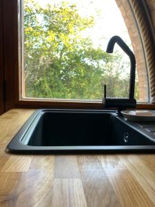a kitchen sink in front of a window at Romantic escape luxury Hobbit house with Hot tub! in Sheerness