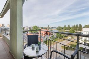 einen Balkon mit einem Tisch und Stadtblick in der Unterkunft Riverside Apartments by Renters in Świnoujście