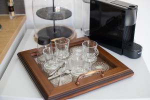 a tray of glasses on a counter next to a microwave at Quinta Salinas - Puro Prazer in Aveiro