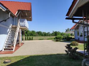 a driveway in front of a house with a staircase at Apartamentai Tigro guolis Rusnėje in Rusnė