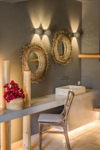 a bathroom with a table and a chair and mirrors at Avithos Resort Hotel in Svoronata