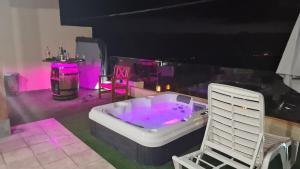 bañera de hidromasaje en una habitación con iluminación rosa en La Casita, en Playa de San Juan