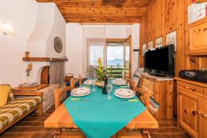 ein Wohnzimmer mit einem Tisch, einem Sofa und einem TV in der Unterkunft Bella Vista 2 in San Zeno di Montagna