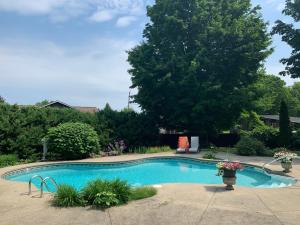 a swimming pool in a yard with a tree at Manoir Alegria in Cowansville