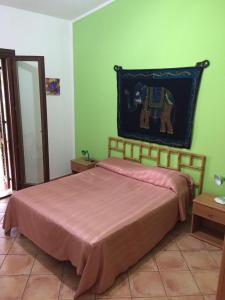 サン・ヴィート・ロ・カーポにあるVilla Esterの緑の壁のベッドルーム1室(ベッド1台付)