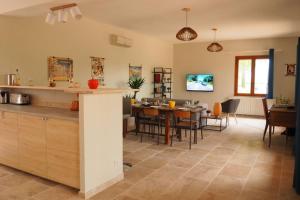 eine Küche und ein Esszimmer mit Tisch und Stühlen in der Unterkunft Maison Le Grand Verger in Goult