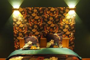 ein Schlafzimmer mit einem Bett mit Blumentapete in der Unterkunft Maison Le Grand Verger in Goult