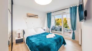 a bedroom with a bed and a large window at 504 Premium Nadmorskie Tarasy przy Latarni i Molo pool sauna fitness garage FREE in Kołobrzeg +52 photos