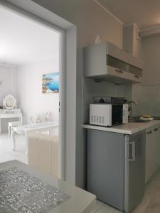 a kitchen with a microwave and a living room at APARTAMENT Magurka in Rycerka Górna