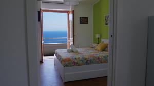 a bedroom with a bed with a view of the ocean at Talìa Residence in San Giorgio
