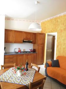 ein Wohnzimmer mit Tisch und Küche in der Unterkunft Il Corallo in San Vito lo Capo