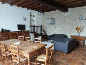 a living room with a wooden table and a couch at Logis Des Bessons in Migron