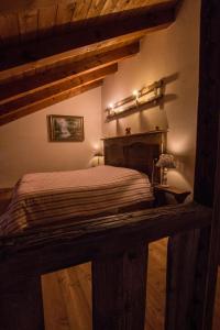 1 dormitorio con 1 cama en una habitación con suelo de madera en Il canto del bosco, en Valpelline