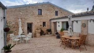 un patio con tavolo e sedie e un edificio di A Staccia a Ragusa