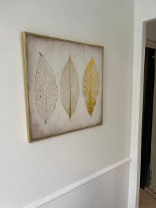 a picture of three leaves on a wall at LE COSY - Lumineux - Proche de Rennes - Spacieux in Liffré