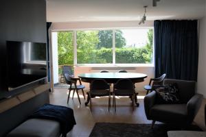 een woonkamer met een tafel en stoelen en een raam bij Baza Lipusz in Lipusz