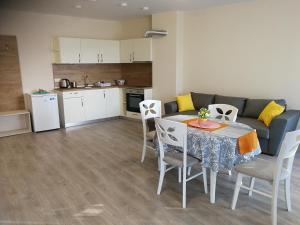 a kitchen and a living room with a table and chairs at Donchevi Apartments in Primorsko