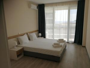 a bedroom with a bed and a large window at Donchevi Apartments in Primorsko +53 photos