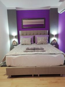 a bedroom with a large bed with purple walls at Apartment Mavero-Free Private Parking in Zagreb