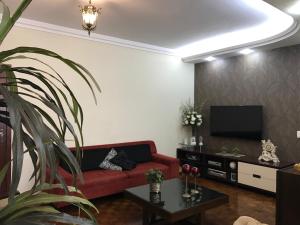 ein Wohnzimmer mit einem roten Sofa und einem Flachbild-TV in der Unterkunft Apartamento Mar da Praia da Costa in Vila Velha