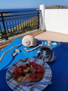 una mesa con un plato de comida y una taza de café en Studios RENA en Fourni Ikarias