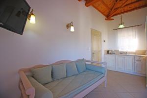 a living room with a blue couch and a kitchen at Mando Beachfront in Stafylos