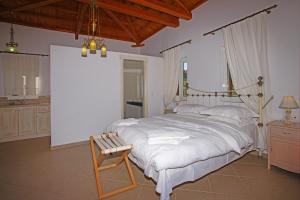a bedroom with a large bed and a wooden bench at Mando Beachfront in Stafylos