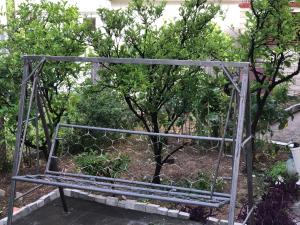 a metal bench sitting in front of a tree at Katarina in Bijela