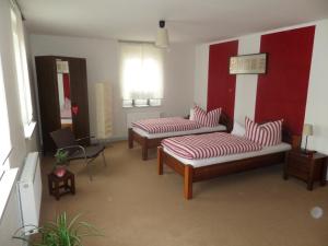 uma sala de estar com dois sofás e uma parede vermelha e branca em Elbflair em Zahna-Elster