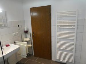 baño con puerta de madera y lavamanos en Haus am Park, en Rommerskirchen