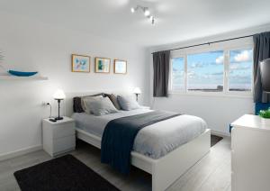 a white bedroom with a bed and a window at Casa Salinas del Mar in Guatiza