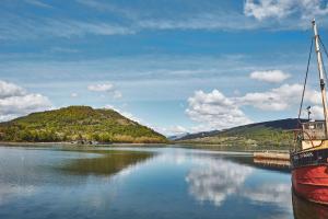 a boat is docked at a dock on a lake at Brambles of Inveraray in Inveraray