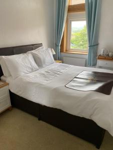 ein großes Bett in einem Schlafzimmer mit Fenster in der Unterkunft Birtley House Bed and Breakfast in Robin Hood's Bay