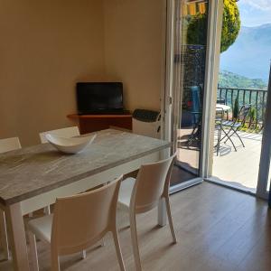 a kitchen with a table and chairs and a balcony at Casa Vacanze Sole in Tremosine Sul Garda