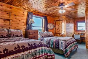 a bedroom with two beds and a ceiling fan at Lodge at OZK Ranch- Incredible mountaintop cabin with hot tub and views in Compton