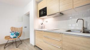 a kitchen with a sink and a chair in a room at Etti Paradise - Suite Oceano in Pájara