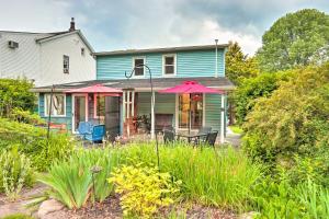 Charming Abode with Patio - Walk to Town and River! في Stockton: منزل أزرق مع مظلتين ورديتين في حديقة