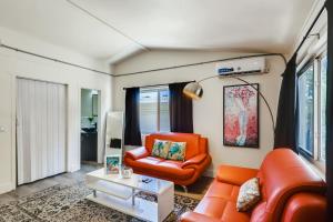 - un salon avec une chaise orange et un canapé dans l'établissement !!Coral Sands 1 Bedroom Stunner!!, à West Palm Beach