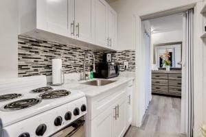 a white kitchen with a stove and a sink at !!Coral Sands 1 Bedroom Stunner!! in West Palm Beach