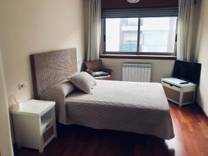 ein Schlafzimmer mit einem Bett, einem Stuhl und einem Fenster in der Unterkunft Hotel Cristaleiro in Gondomar