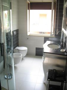 a bathroom with a toilet and a sink and a window at Residence Uliveto e Casa Anna in Garda