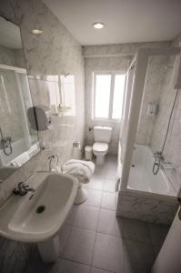 ein Badezimmer mit einem Waschbecken, einer Badewanne und einem WC in der Unterkunft Hotel Vigo Plaza in Vigo