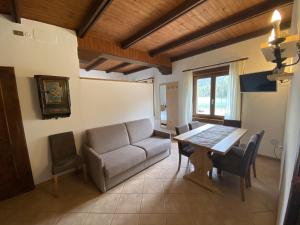 a living room with a couch and a table and chairs at Appartamenti Sorapiss in Misurina